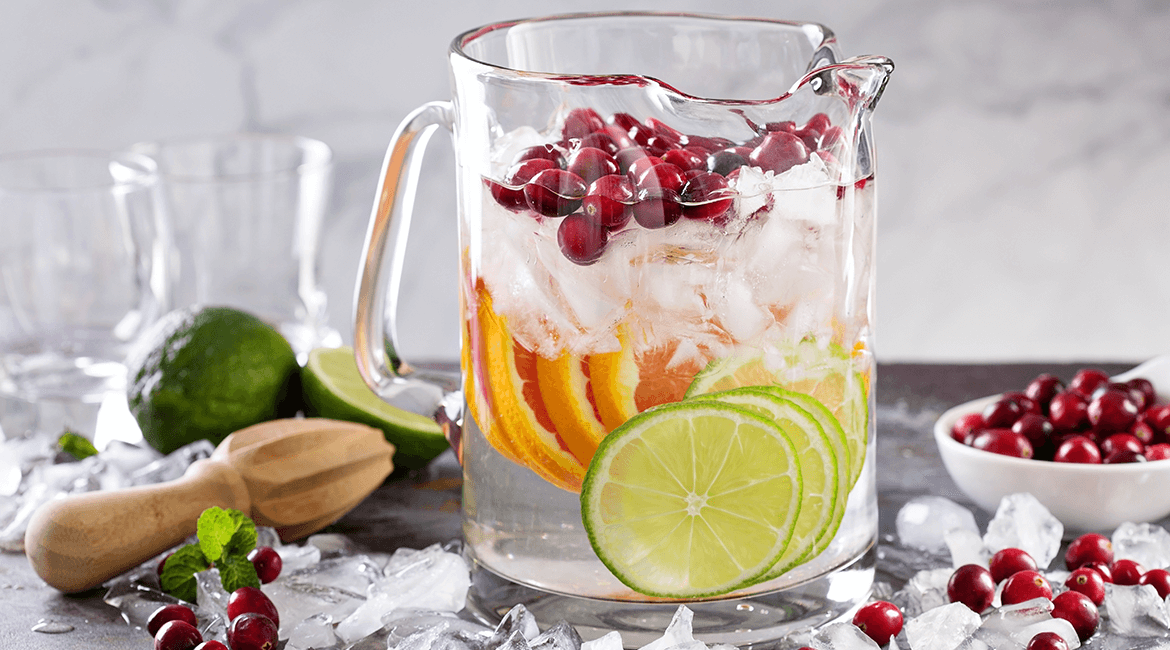 pitcher of water with berries and fruits.
